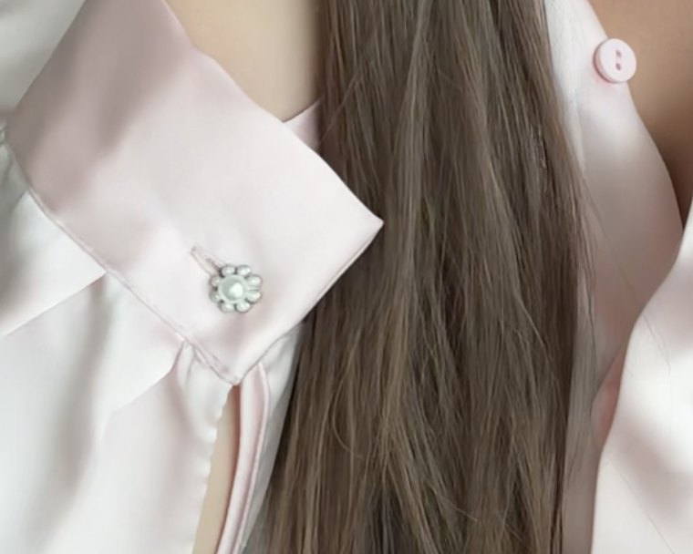 A small pearl button on a satin cuff